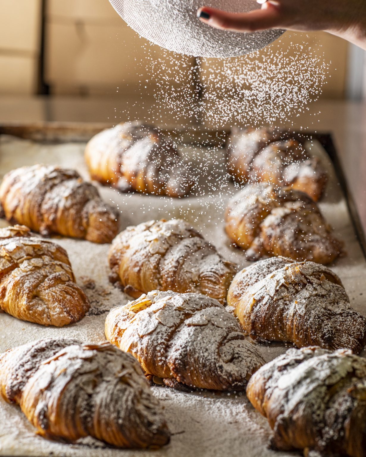 Scrumptious almond croissant on a wooden board, showcasing its flaky layers and almond filling