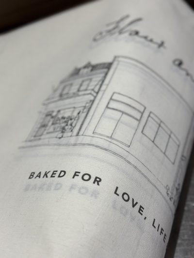Flour and Stone tea towel featuring the printed text 'BAKED FOR LOVE, LIFE'